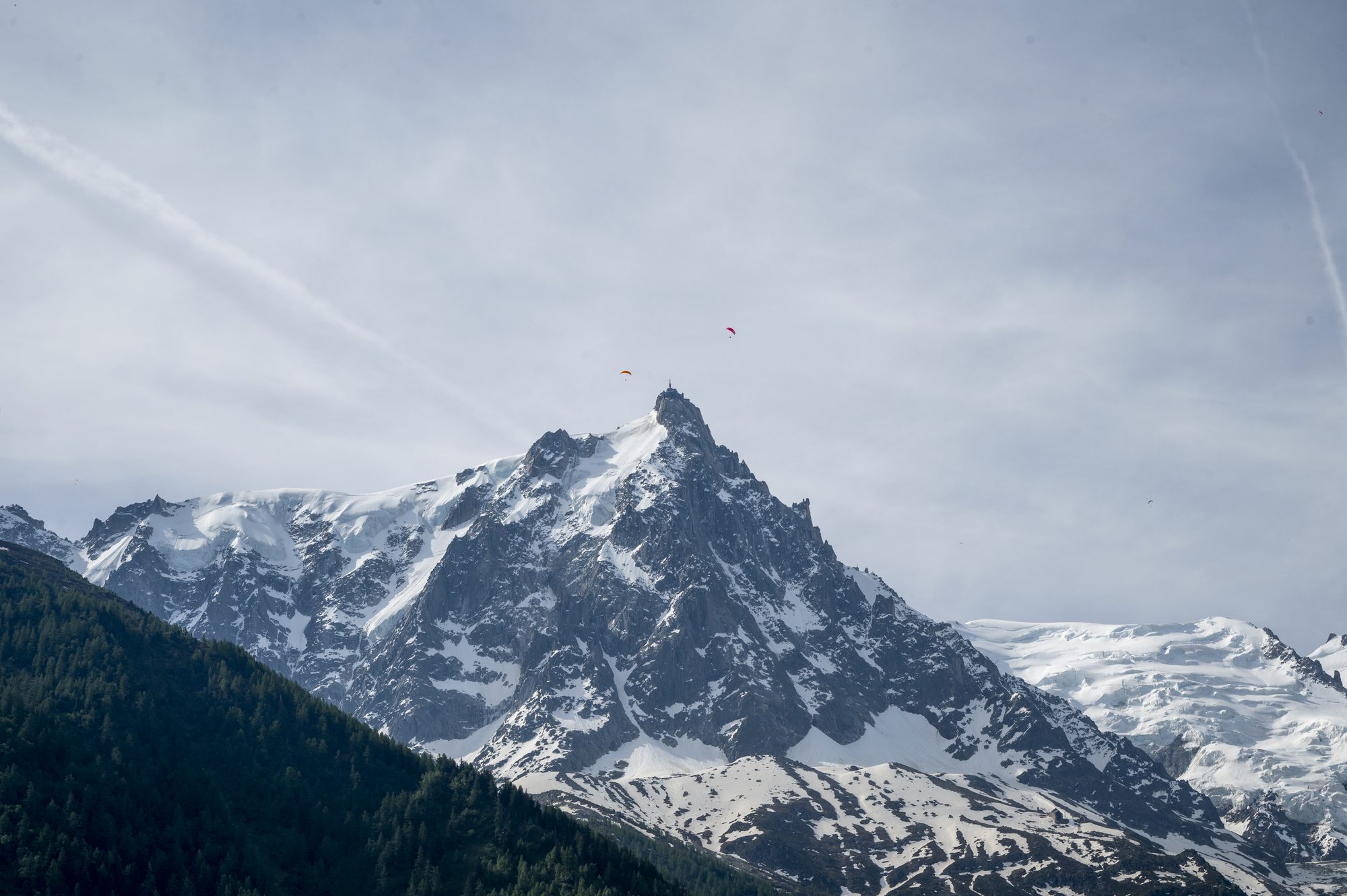 Jagged snow-capped mountain peak under a hazy sky